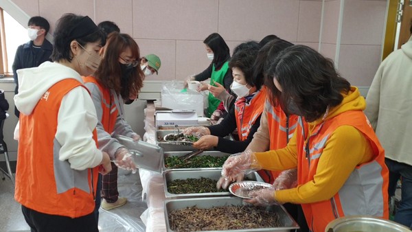음식 퍼 나르기를 하는 자원봉사자들